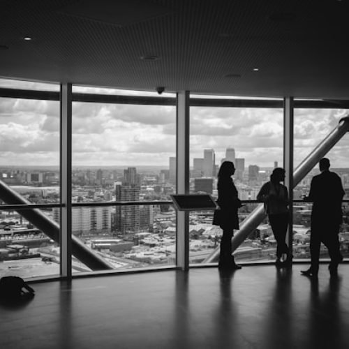 Three individuals working together with a city scene outside the windows.